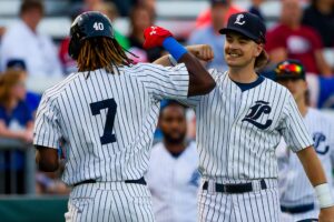 Baseball players congratulate each other with a fist bump.