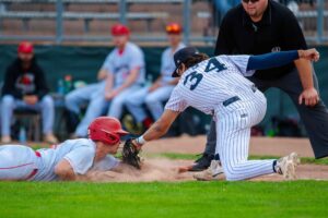 A baseball player gets tagged sliding into the base.