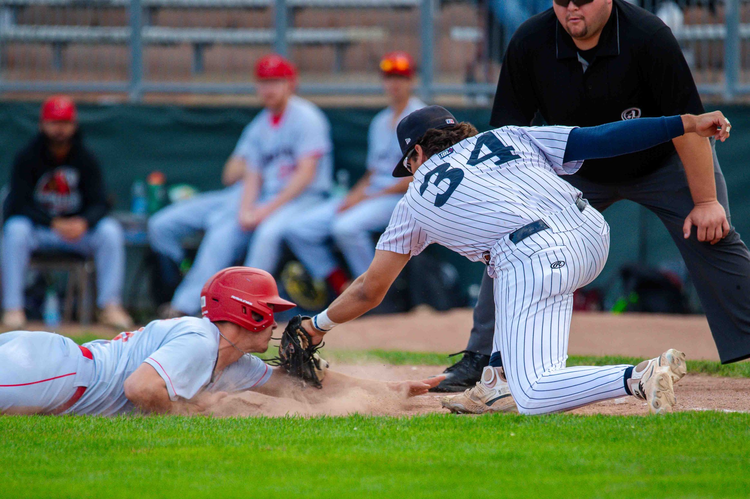 A baseball player gets tagged sliding into the base.