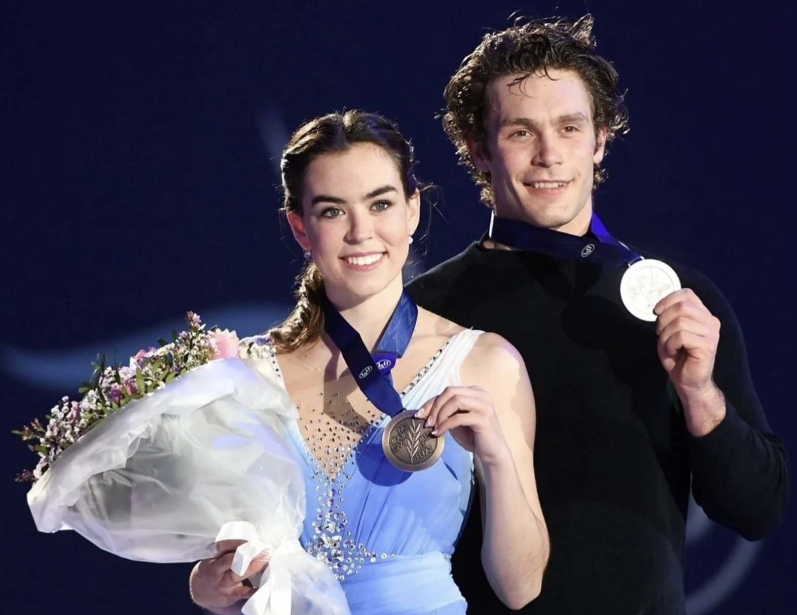 Two figure skaters holding their medals
