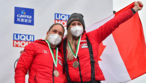 Two women holding a Canadian flag.