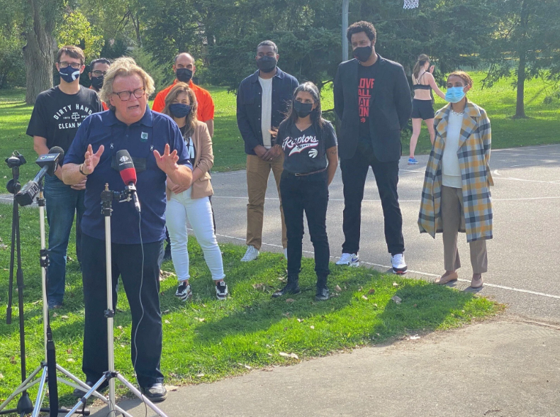 A group of people standing in front of a microphone at a press conference.