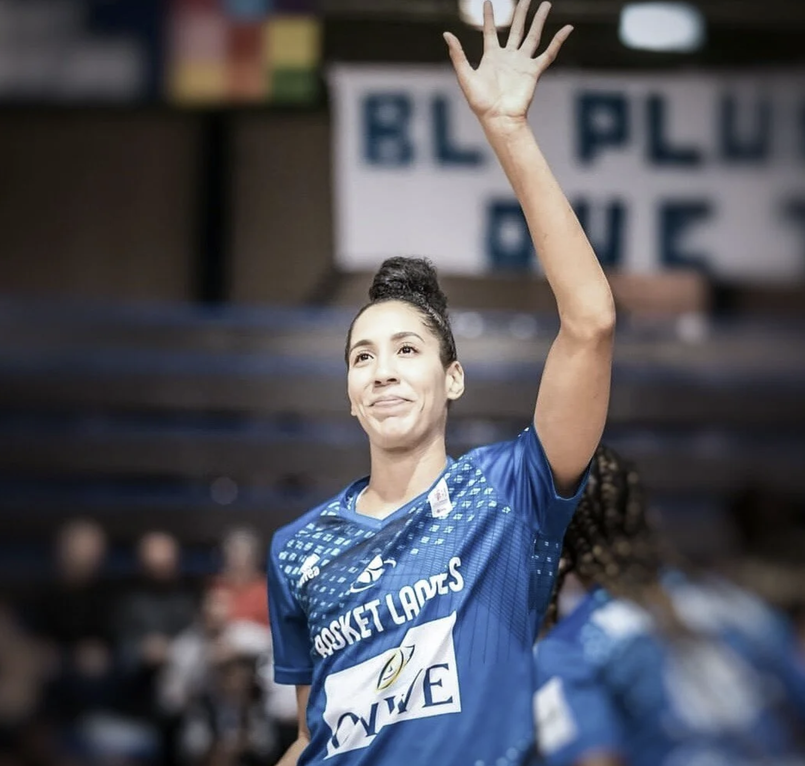 A woman raising her left hand.