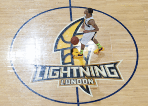 A basketball player walks across the court overtop the London Lightning logo.